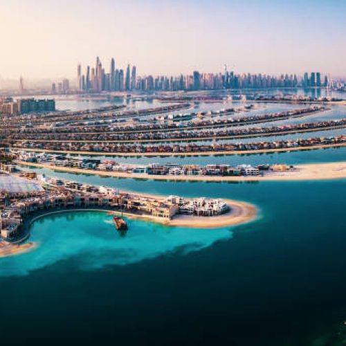 The Palm island panorama with Dubai marina rising in the background aerial view